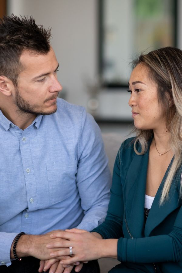 Olive-Counselling-Couples-Counselling-Vancouver-British-Columbia Couple looking at each other and holding hands in a couples counselling session