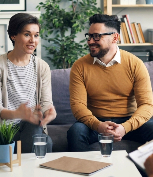 Middle aged couple in a couples counselling session. Talking to therapist who is behind the camera.